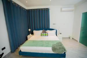 a bedroom with a large bed with blue drapes at The Pearl - Lincoln - 2nd floor in Kumasi