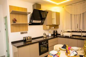 a kitchen with a counter top with a stove top oven at The Pearl - Lincoln - 2nd floor in Kumasi