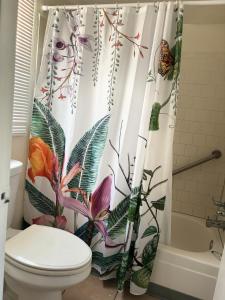 a bathroom with a shower curtain with flowers and butterflies at Jasmine Garden Inn - Lake City in Lake City