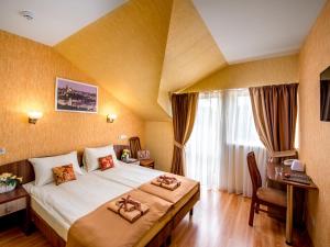 リヴィウにあるHotel&SPA Pysanka, Готель Писанка, 3 сауни та джакузі - індивідуальний відпочинок у СПАの大きなベッドとデスクが備わるホテルルームです。