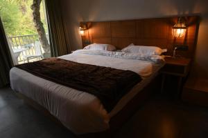 a large bed in a bedroom with a window at Kabana de Nature in Rājgarh