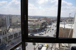 una finestra con vista su una strada della città di Omayah hotel irbid a Irbid