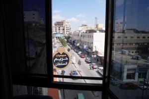 una finestra con vista su una strada della città di Omayah hotel irbid a Irbid