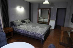 a small bedroom with a bed and a mirror at Omayah hotel irbid in Irbid