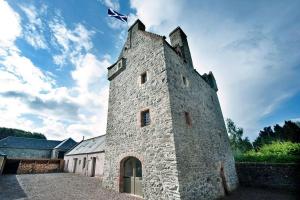 een stenen gebouw met een vlag erop bij Aikwood Tower in Selkirk