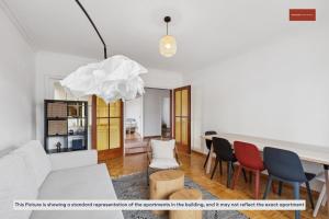 a living room with a table and chairs at 15-Min to Zurich Center: Cozy Apartment in Zurich