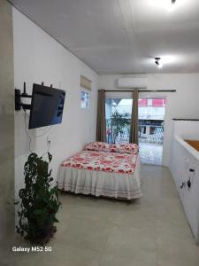 a bedroom with a bed and a flat screen tv at Studio com varanda - Melhor localização do Arruda in Recife