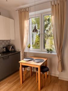 a kitchen with a wooden table and a window at Apartament Gdynia z duszą in Gdynia