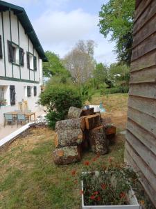 une pile de bûches assises à côté d'une maison dans l'établissement Le chant des oiseaux, à Cambo-les-Bains