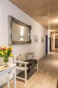 een woonkamer met een bank en een spiegel aan de muur bij Hotel Cronberger Hof in Ladenburg