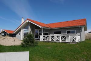 une maison avec un toit orange sur une plage dans l'établissement Resort 2 Ferienhaus Typ D 104, à Großenbrode