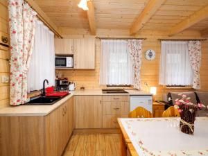 uma cozinha com armários de madeira e uma mesa num camarote em Domki i Pokoje obok Term Chochołów U Tadka em Chochołów