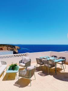 a patio with a table and chairs and the ocean at Benagil Beach House - Victoria in Lagoa
