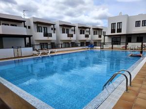 a large swimming pool in front of some buildings at Duplex Noray vista a la piscina in Puerto Calero