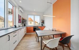 an orange and white kitchen with a table and chairs at Beautiful Apartment In Eilenburg in Eilenburg