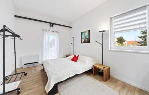 a white bedroom with a bed and a window at Beautiful Apartment In Eilenburg in Eilenburg +2 photos