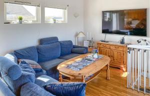 雪平斯维克5 Bedroom Stunning Home In Köpingsvik的客厅里有一张蓝色的沙发和一张桌子