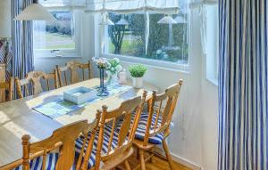 雪平斯维克5 Bedroom Stunning Home In Köpingsvik的一间有桌子、椅子和窗户的餐厅