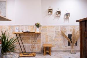 a room with a stone wall with a shelf and a table at Onar Syros - Rustic Rooms in Ermoupoli