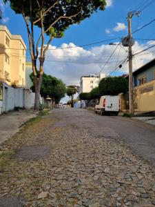 an empty street with a white van parked on the road at Seu Cantin em BH Venda Nova in Belo Horizonte