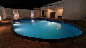 a large blue swimming pool in a building at Luxury Villa with Swimming Pool in Jaipur