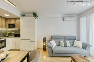 uma sala de estar com um sofá e uma cozinha em Can Muntaner Duplex em Palamós