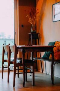 mesa de comedor de madera y sillas con jarrón en Eco-friendly WelnessCabin in Liglet en Liglet