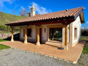 Casa blanca pequeña con terraza de madera en Casa rural en Fontibre, en Espinilla