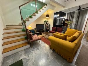 シャー・アラムにあるFarahuna Houseのリビングルーム(黄色のソファ、階段付) +3枚の写真