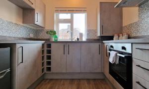 a kitchen with stainless steel cabinets and a sink at Luxury Family Apartment- Close to Leicester University in Leicester
