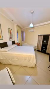 a bedroom with a large white bed in a room at Hotel Rio Branco in Jequié