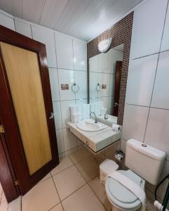 y baño con aseo, lavabo y espejo. en Hotel Beach Hills, en Porto Seguro