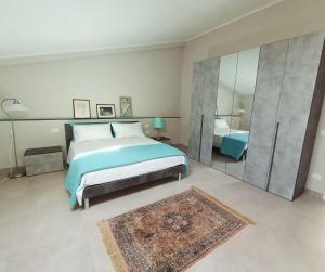 ein Schlafzimmer mit einem großen Bett und einem Spiegel in der Unterkunft Le Giramondo Appartamento Carolina in Caserta