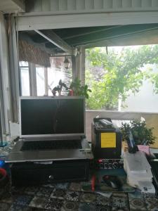 een laptop op een bureau naast een raam bij Pangea Sığacık Pansiyon & Bistro in Seferihisar