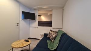 ein Wohnzimmer mit einem blauen Sofa und einem Tisch in der Unterkunft Le Carnotzet Tchiko in Savièse