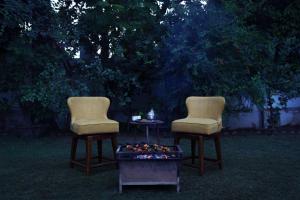 two chairs sitting next to a table with a fire pit at Luxury Villa with Swimming Pool in Jaipur