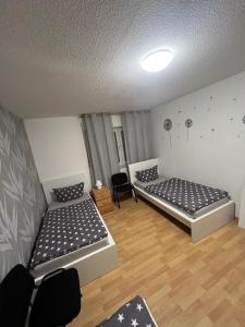 Habitación con suelo de madera y 2 camas. en Fewo 6, en Gotha