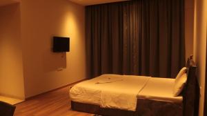 een hotelkamer met een bed en een televisie bij Niva Stays Riverside 1 in Kharadi