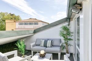 uma varanda com uma cadeira azul e plantas em Can Muntaner Duplex em Palamós