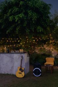 a guitar and a chair next to a wall with lights at Luxury Villa with Swimming Pool in Jaipur