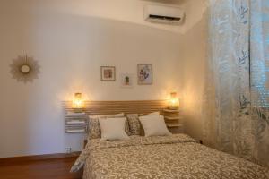 1 dormitorio con 1 cama y 2 luces en la pared en Terrazza Romana en Roma