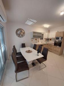 a kitchen with a white table and leather chairs at Spacious 3 Bedroom Apartment 50m from Sea 2 Bathrooms 2 Terraces Near Beach in Privlaka