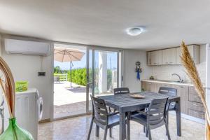 eine Küche und ein Esszimmer mit einem Tisch und Stühlen in der Unterkunft Casa Gianna in Marina di Pescoluse