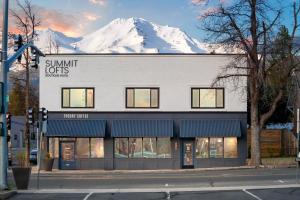 a building with a snow covered mountain in the background at Summit Lofts Boutique Hotel in Mount Shasta
