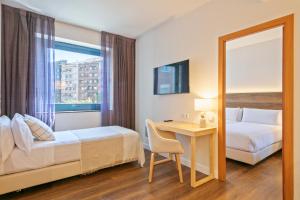 a hotel room with a bed and a desk and a mirror at Hotel Acta Azul Barcelona in Barcelona