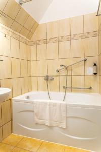 een badkamer met een wit bad en een wastafel bij NOVA.Galicja in Nowy Sącz