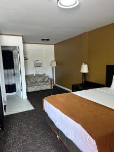 a hotel room with a large bed and a couch at NORTHERN MOTEL in Sault Ste. Marie