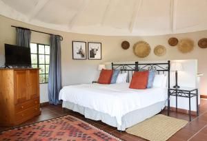 a bedroom with a bed and a flat screen tv at Kings Grant Country Retreat in Ixopo