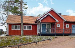 una casa roja con un árbol delante en Pet Friendly Home In Hgsby With Kitchen, en Högsby