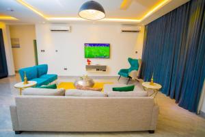 een woonkamer met een bank en stoelen bij The Pearl - Bountiful - 1st floor in Kumasi